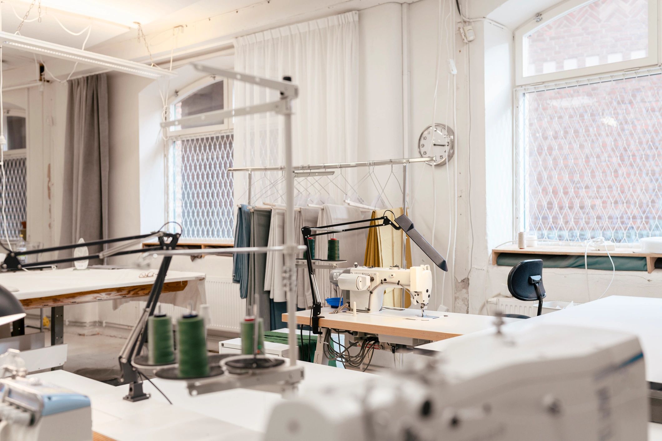 Garment production workshop with sewing stations and fabric tables